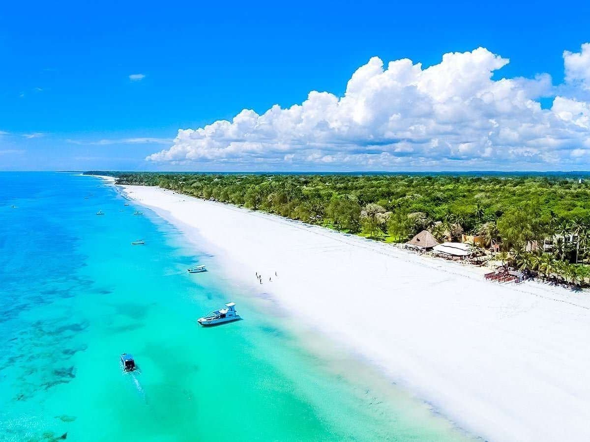 Aerial view of Diani's white-sand beach and turquoise water beside Nomad Beach Resort