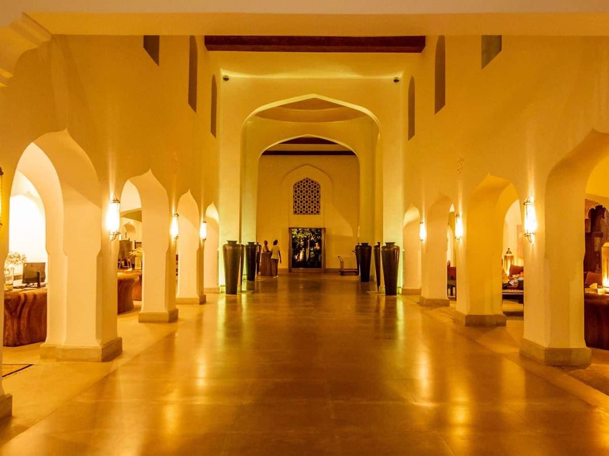 Lantern-lit Swahili arches lining a long marble corridor at Swahili Beach Resort